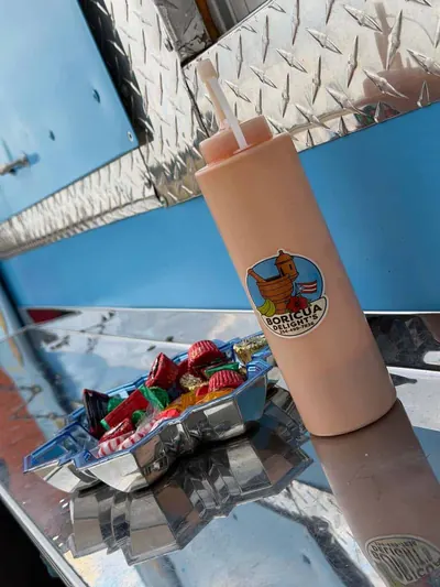 Squeeze bottle of house mayoketchup with the Boricua Delight logo on the food truck counter